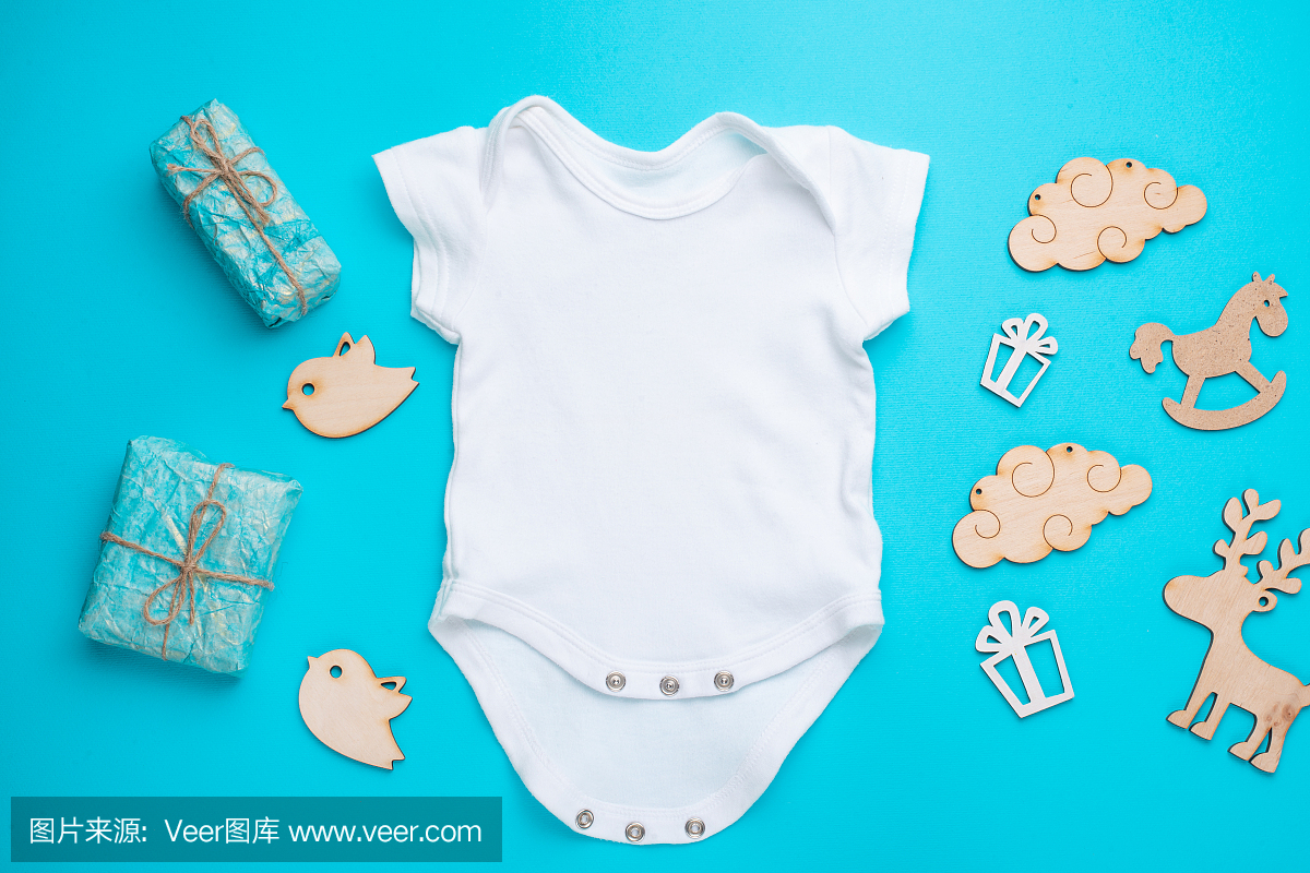 平铺一件白色儿童衬衫,上面有木制玩具和礼物,以蓝色为背景。logo、广告、儿童派对迎婴派对、儿童生日派对的布局设计与放置